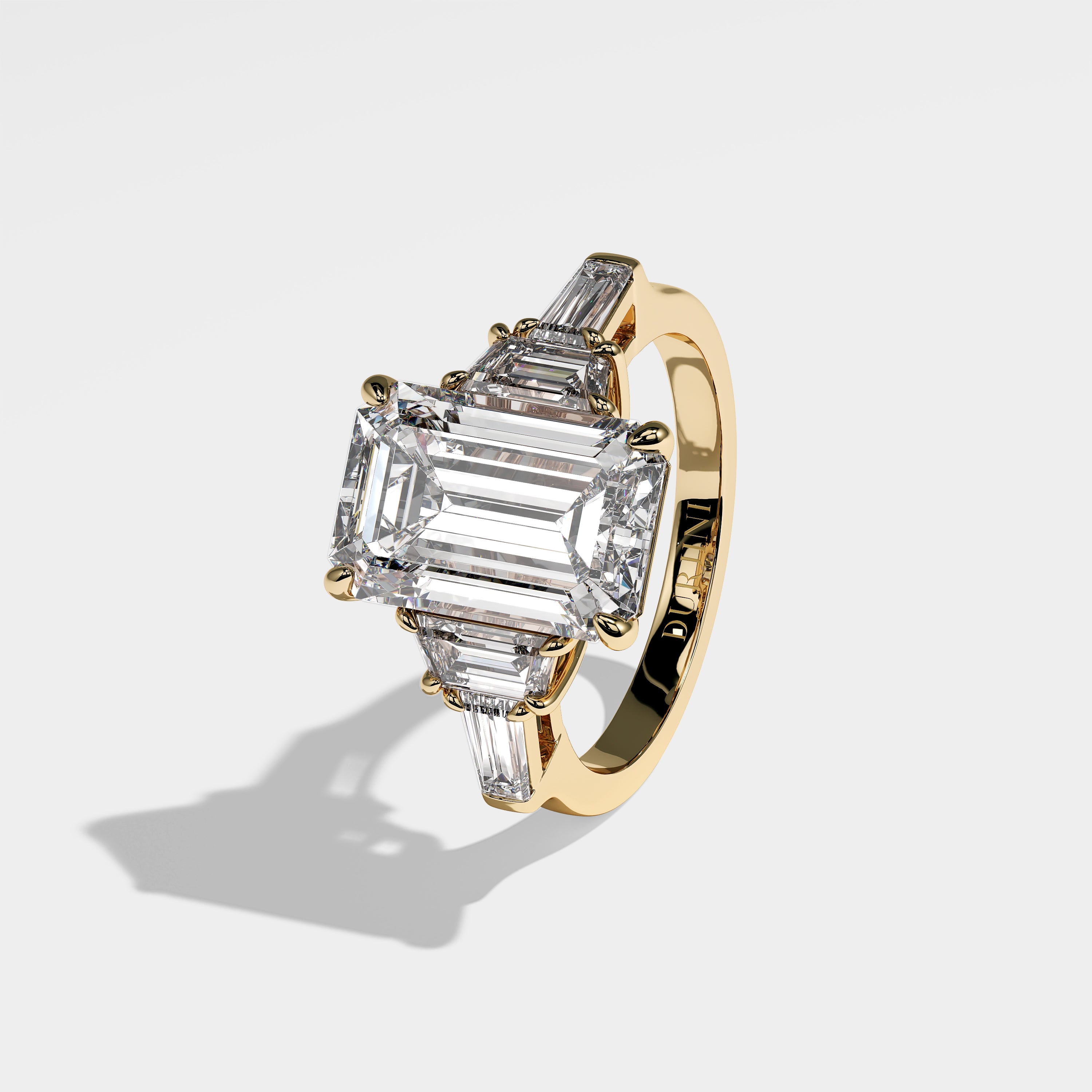 Isabella emerald-cut diamond engagement ring in 18K yellow gold by Kurbani Durjini, left side view