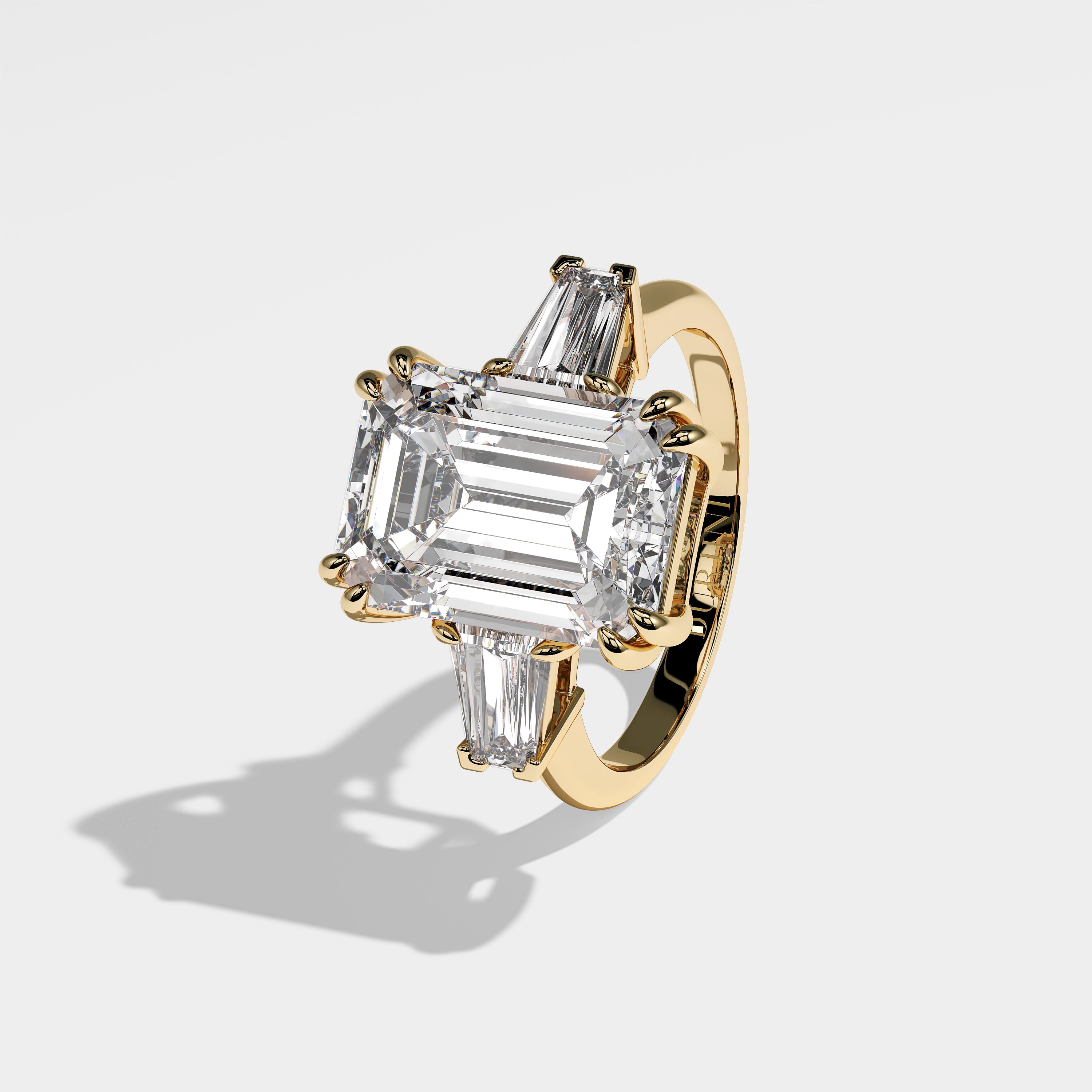 Sofia emerald-cut diamond engagement ring in 18K yellow gold by Kurbãni Durjini, left view